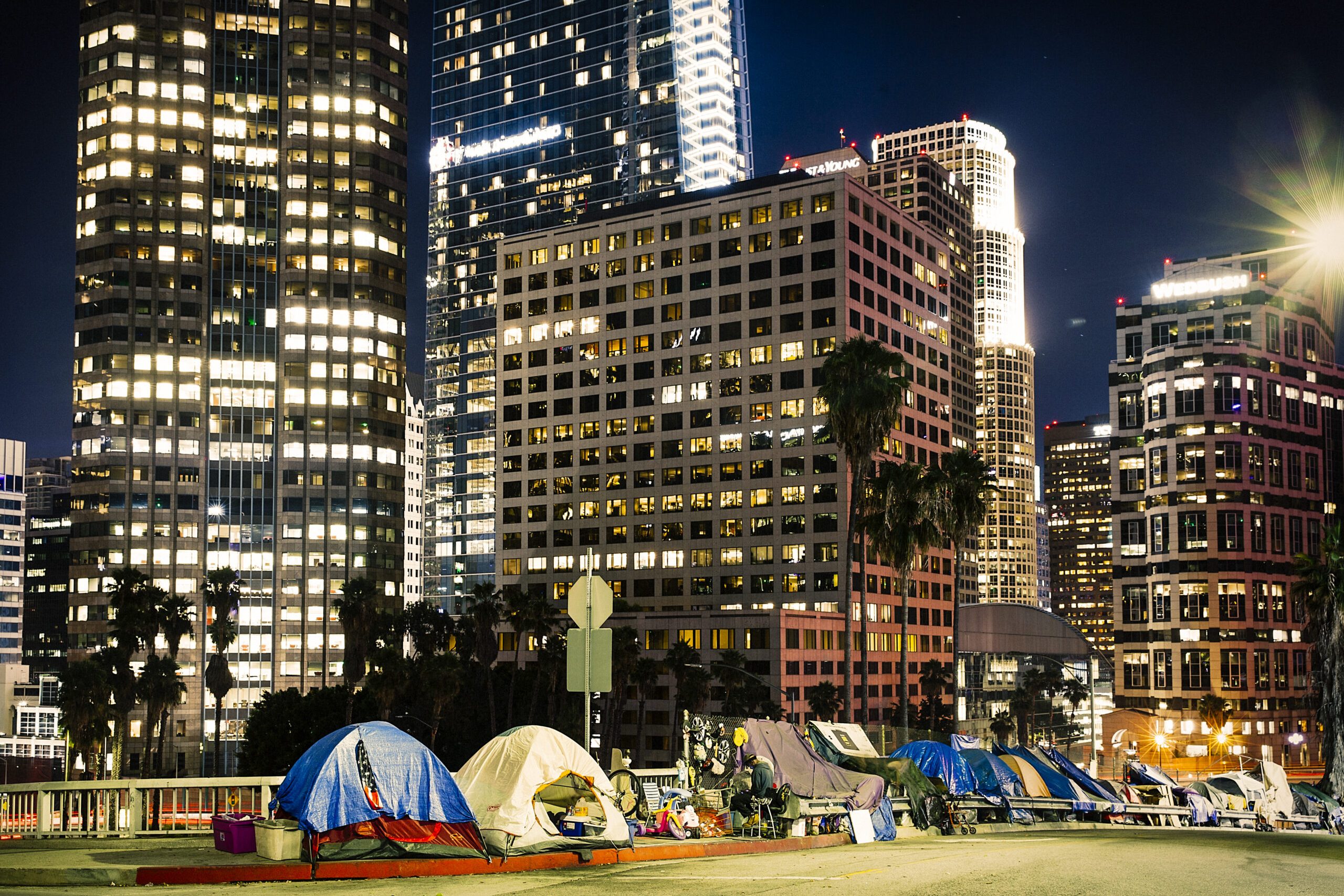 Los Angeles, CA, USA - September 2018:  View of homeless people tents near the highway in LA Downtown with skyscrapers.